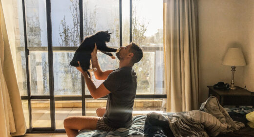 homme qui tient un chat dans ses bras