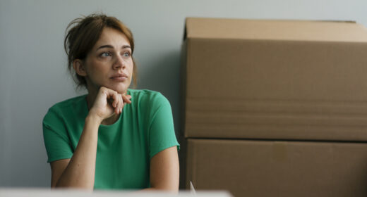 Une femme pensive près de cartons dans un bureau