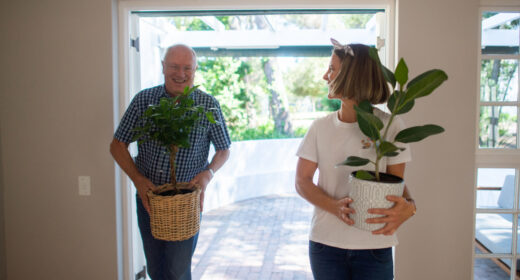 Father helping Daughter carry and move plants into her new sunny apartment
