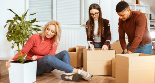 Packing various things and in boxes during moving to another apartment. Relocation. Multi-ethnic and multi-racial group of people.